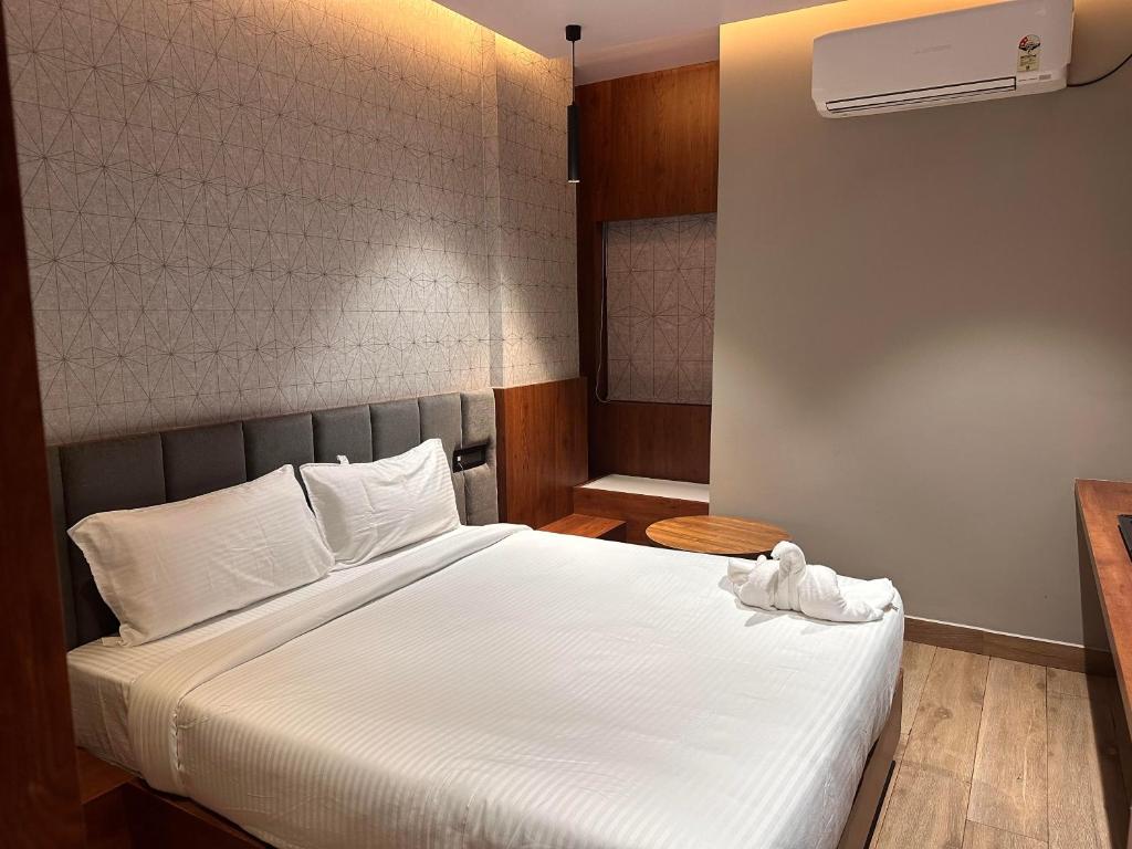 a bedroom with a white bed and a air conditioner at V HOTEL in Brahmapur