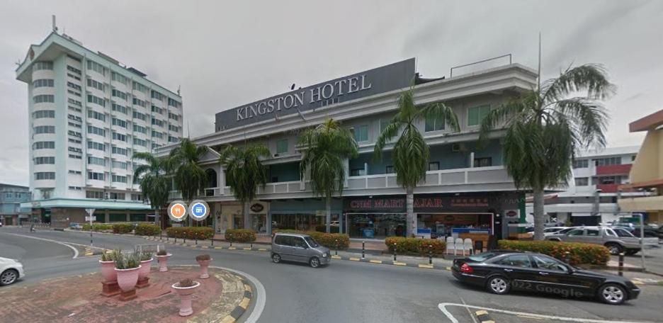 a large building with cars parked in front of it at Kingston Executive Hotel in Tawau