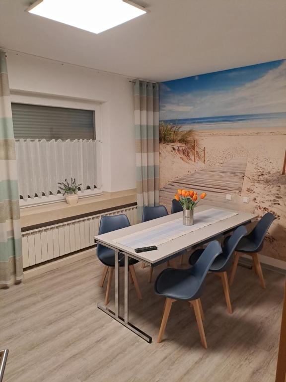 een eetkamer met een tafel en blauwe stoelen bij 7D Apartment mit 3 Schlafzimmern in Castrop-Rauxel