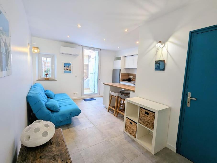 a living room with a blue couch and a kitchen at Entre calanques et vieux port ! in La Ciotat
