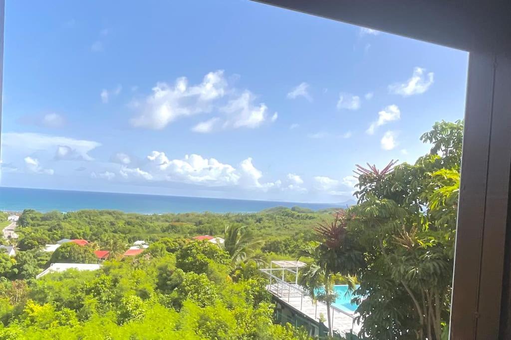 Una vista del océano desde el balcón de un resort. en L'appartement FRUIT DE LA PASSION, en Le Gosier