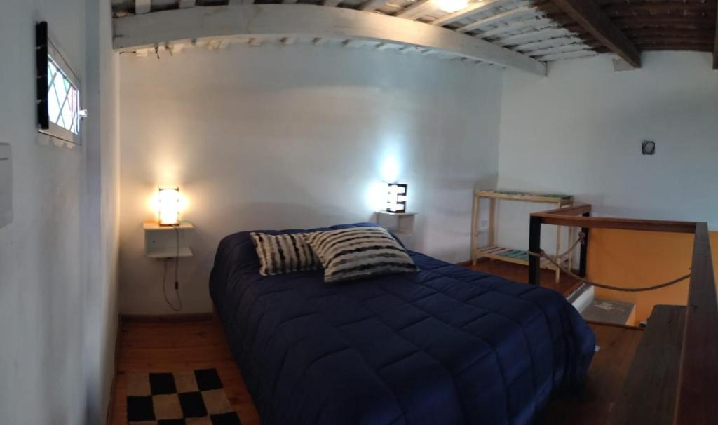 um quarto com uma cama num quarto com 2 candeeiros em The Rustic Hause 2 em Gualeguay