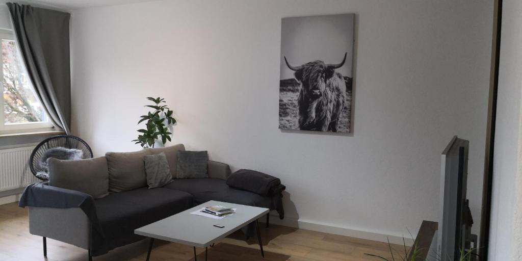 a living room with a couch and a picture of a bull on the wall at Im Herzen von Hauenstein in Hauenstein