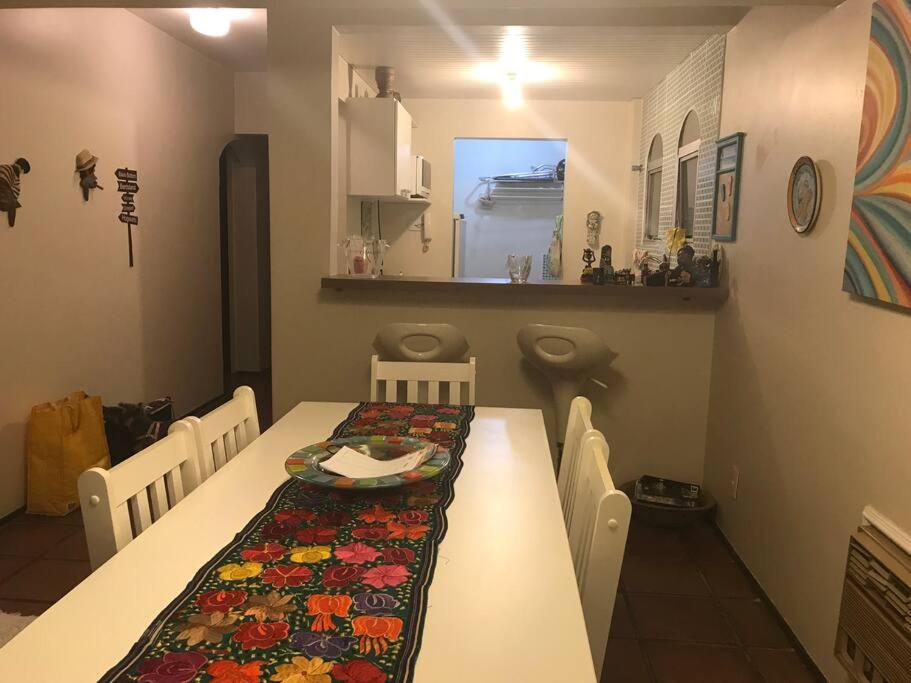 uma sala de jantar com mesa e cadeiras e uma cozinha em Apartamento muito charmoso na praia da Enseada no Guarujá