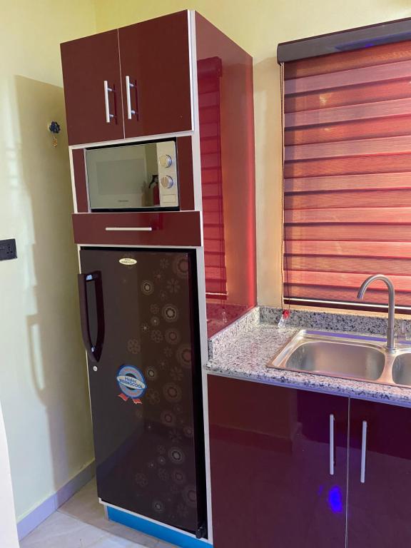 a small kitchen with a refrigerator and a sink at MOK Apartments & Suites in Lagos