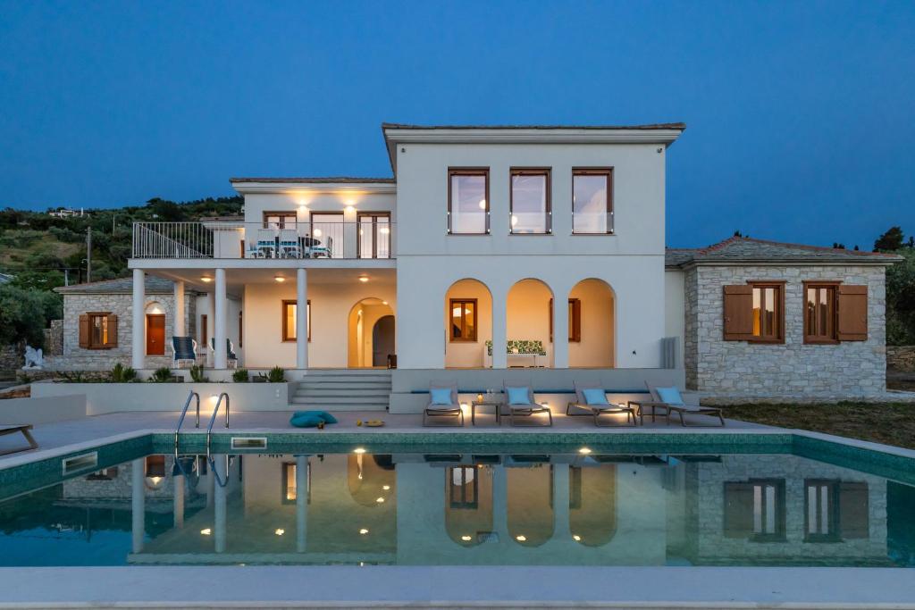 una casa con piscina frente a ella en Sunshine Pool Villa near the Sea, en Skopelos Town