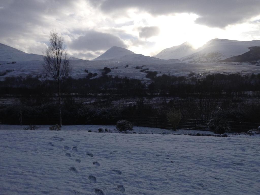 a snow covered field with mountains in the distance at Maol Ruadh in Roybridge