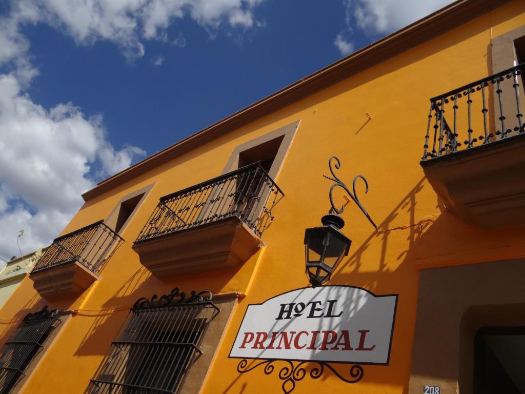 un edificio amarillo con un cartel para el director del hotel en Hotel Principal, en Oaxaca City