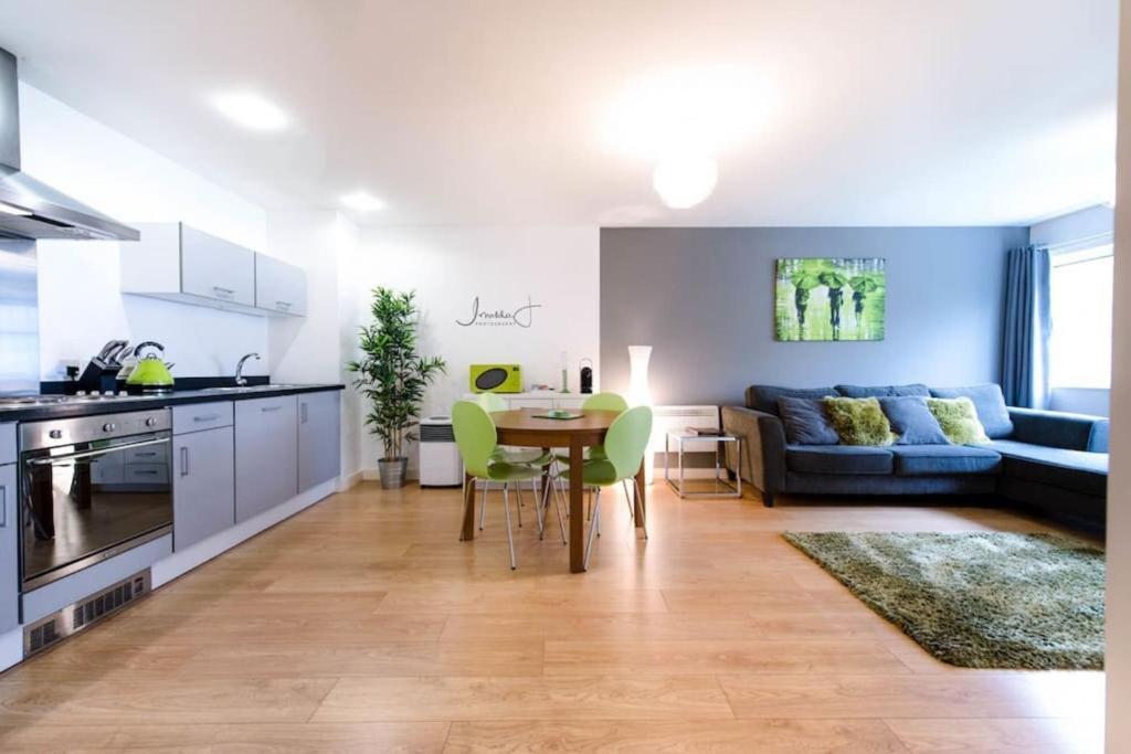 a kitchen and living room with a table and a couch at Modern 1KB 1DB Apt - Salford Quays in Manchester