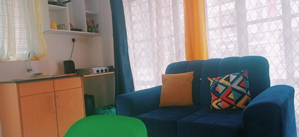 einen blauen Stuhl mit Kissen im Wohnzimmer in der Unterkunft Monika's Bliss Apartment in Nairobi