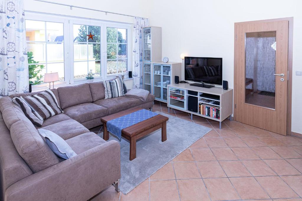 a living room with a couch and a tv at Ferienhaus Satelsrönne 23 - Wattlaeufer in Duhnen