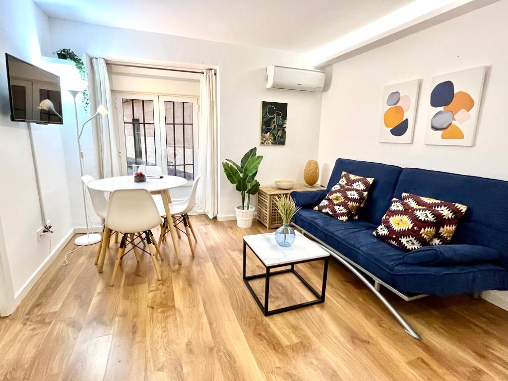 un soggiorno con divano blu e tavolo di Exclusive Apartment in Historic Center a Madrid