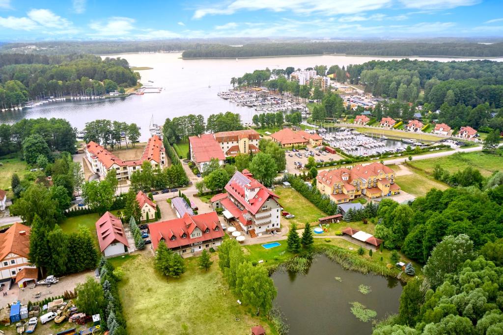 Aerial view of lakeside resort showing marina, red-roof buildings and surrounding forested shoreline.