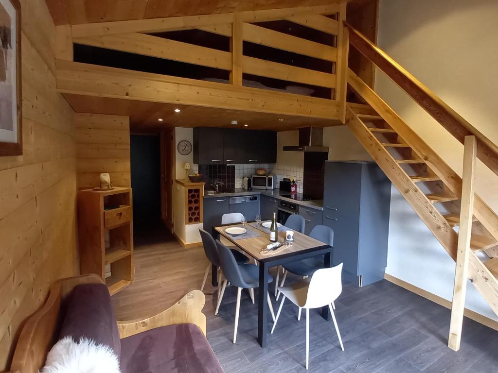 een keuken en eetkamer met een tafel en een trap bij Appartement Le Grand-Bornand, 2 pièces, 5 personnes - FR-1-467-26 in Le Grand-Bornand