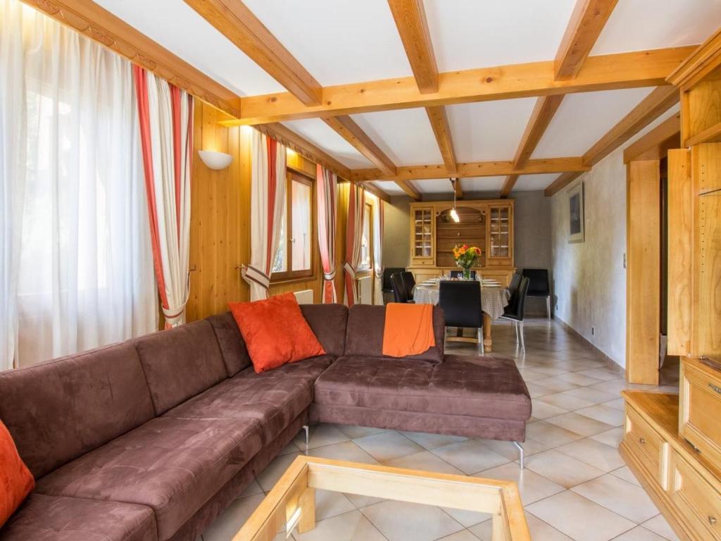 un soggiorno con divano marrone e tavolo di Appartement Le Grand-Bornand, 3 pièces, 9 personnes - FR-1-467-98 a Le Grand-Bornand