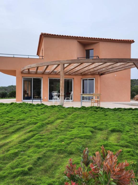 ein Haus mit großem Rasen davor in der Unterkunft Villa La Ronde des Soleils in Coti-Chiavari