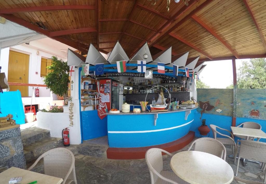 un bar en un restaurante con mesas y sillas en Milos Apartments, en Elounda