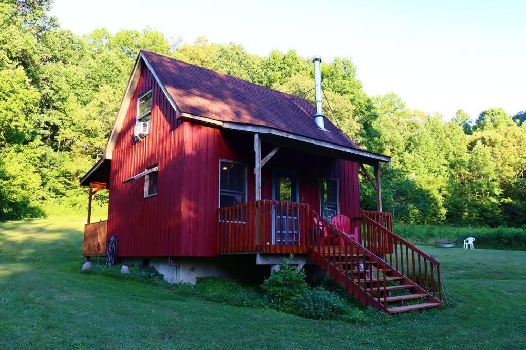 un granero rojo con una escalera roja en un campo en Secluded Cabin on Red Haven Farm, en Irvine