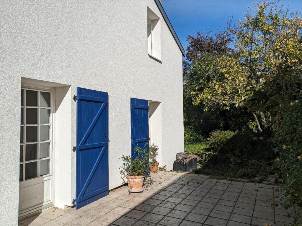 a white house with blue doors on it at LES VOLETS BLEUS in Metz