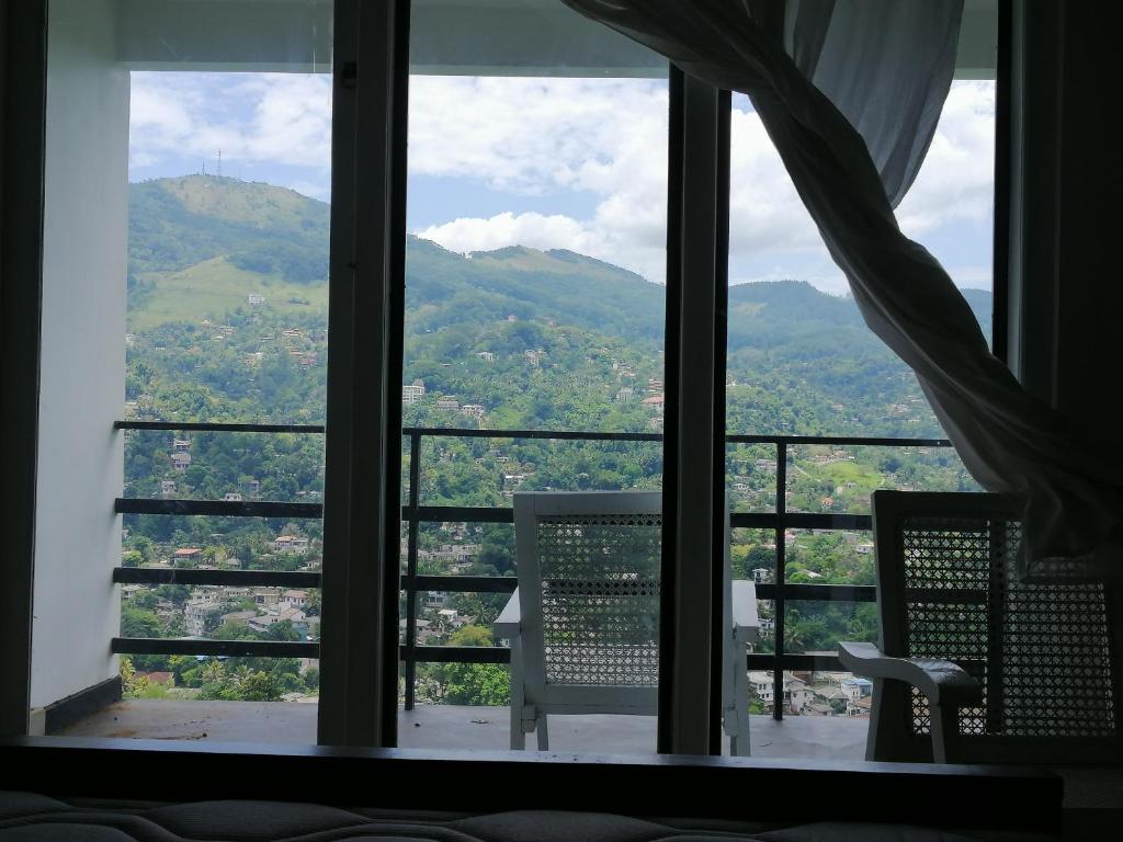 a room with a window with a view of mountains at Glenview hotel & homestay in Kandy