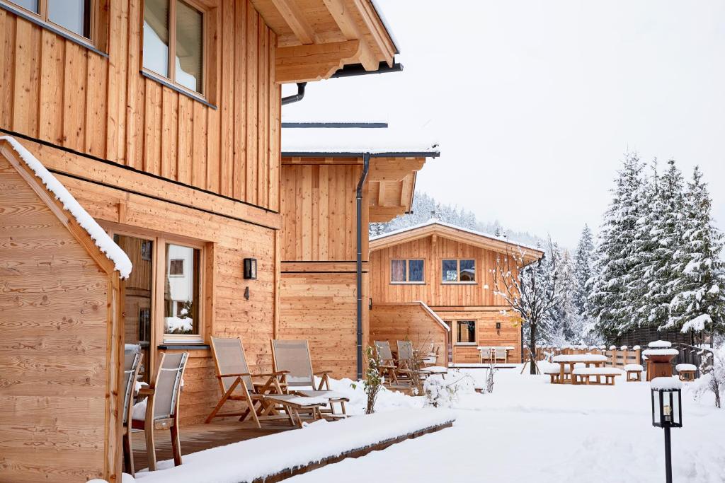 a wooden house with a patio in the snow at Zugspitz Lodge in Ehrwald