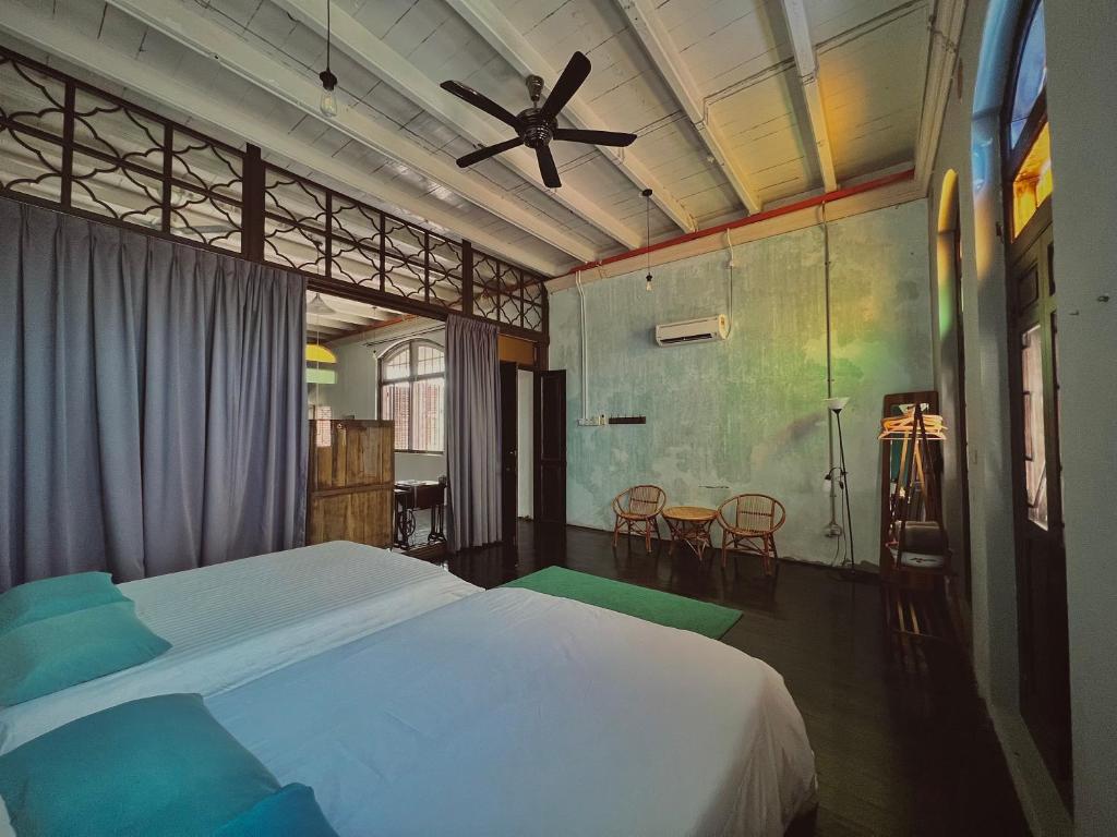 ein Schlafzimmer mit einem Bett und einem Deckenventilator in der Unterkunft CHCH by LEJU in Malakka