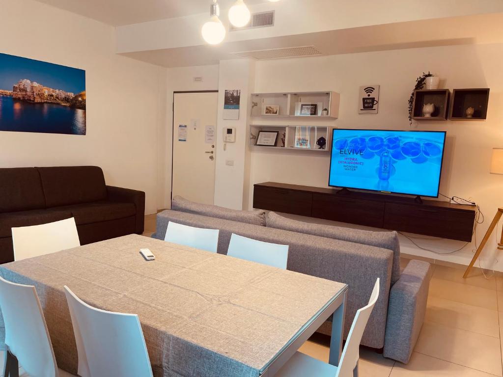 a living room with a table and a couch and a television at Berga Exclusive Suite 5 in Bari