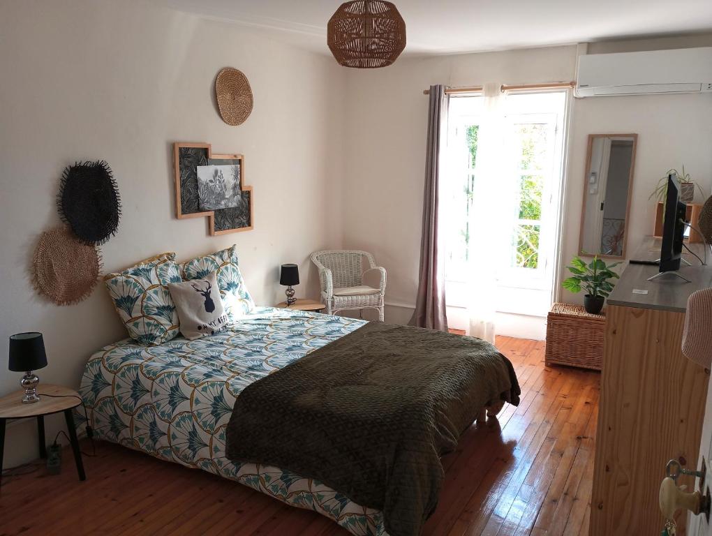 um quarto com uma cama e uma grande janela em La Dolce Vita Camille em Vals-les-Bains