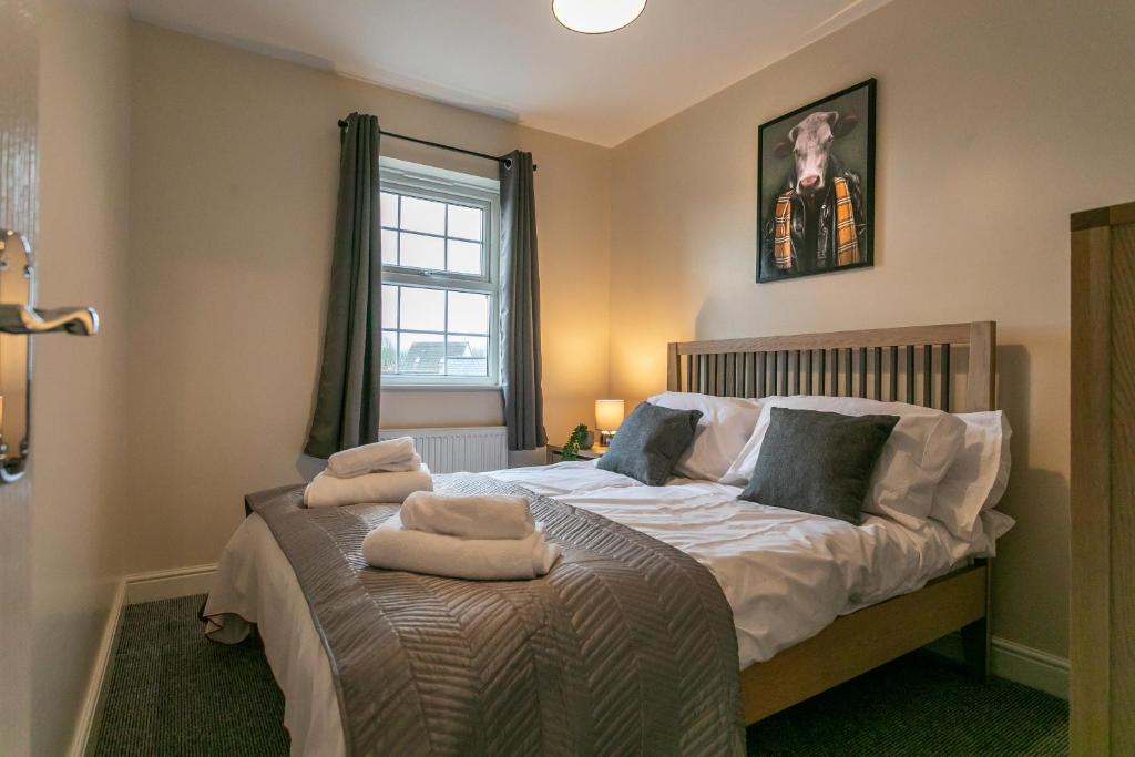 a bedroom with a bed with two towels on it at The Durham House in Leyland