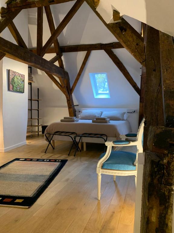 een slaapkamer met een bed en 2 stoelen op een zolder bij galerie jacqueline storme in Lille