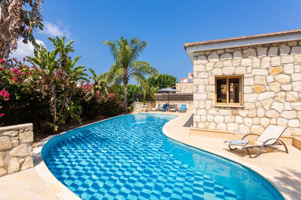 a swimming pool in front of a house at Villa Windmill in Polis Chrysochous