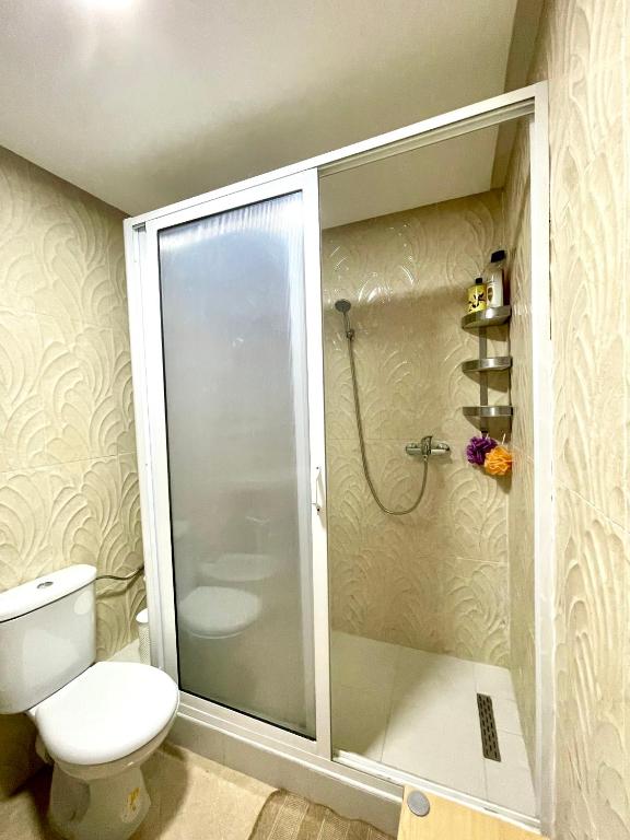 a bathroom with a toilet and a glass shower at Appartement Tanger Moulay Ismail in Tangier