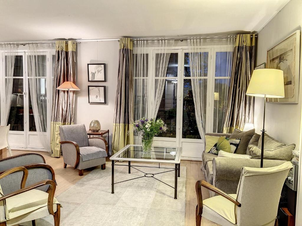een woonkamer met een bank en een tafel bij Paris Porte d'Auteuil 2 BR Apartment in Parijs