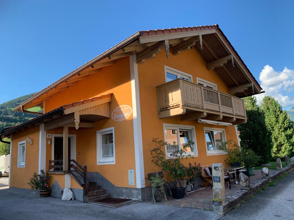 ein orangefarbenes Haus mit Balkon an der Seite in der Unterkunft Landhaus Brandner in Bramberg am Wildkogel