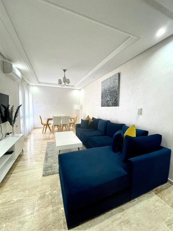 a living room with a blue couch and a table at Appartement Tanger Moulay Ismail in Tangier