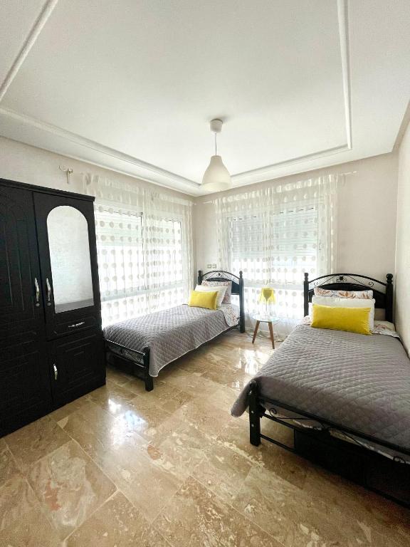 a bedroom with two beds and a window at Appartement Tanger Moulay Ismail in Tangier