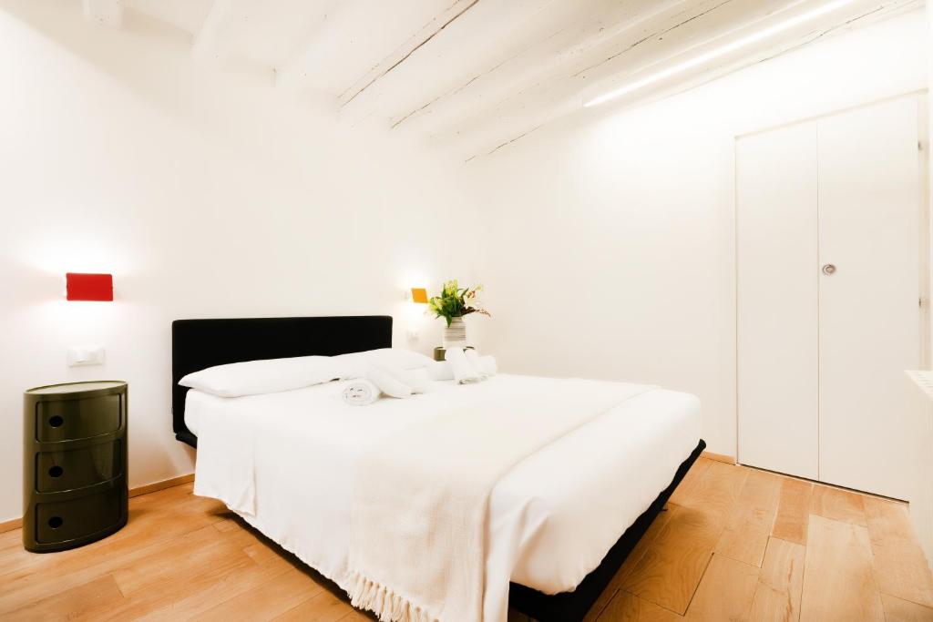 a white bedroom with a large bed with white sheets at Santa Margherita, casa accogliente e confortevole in Venice