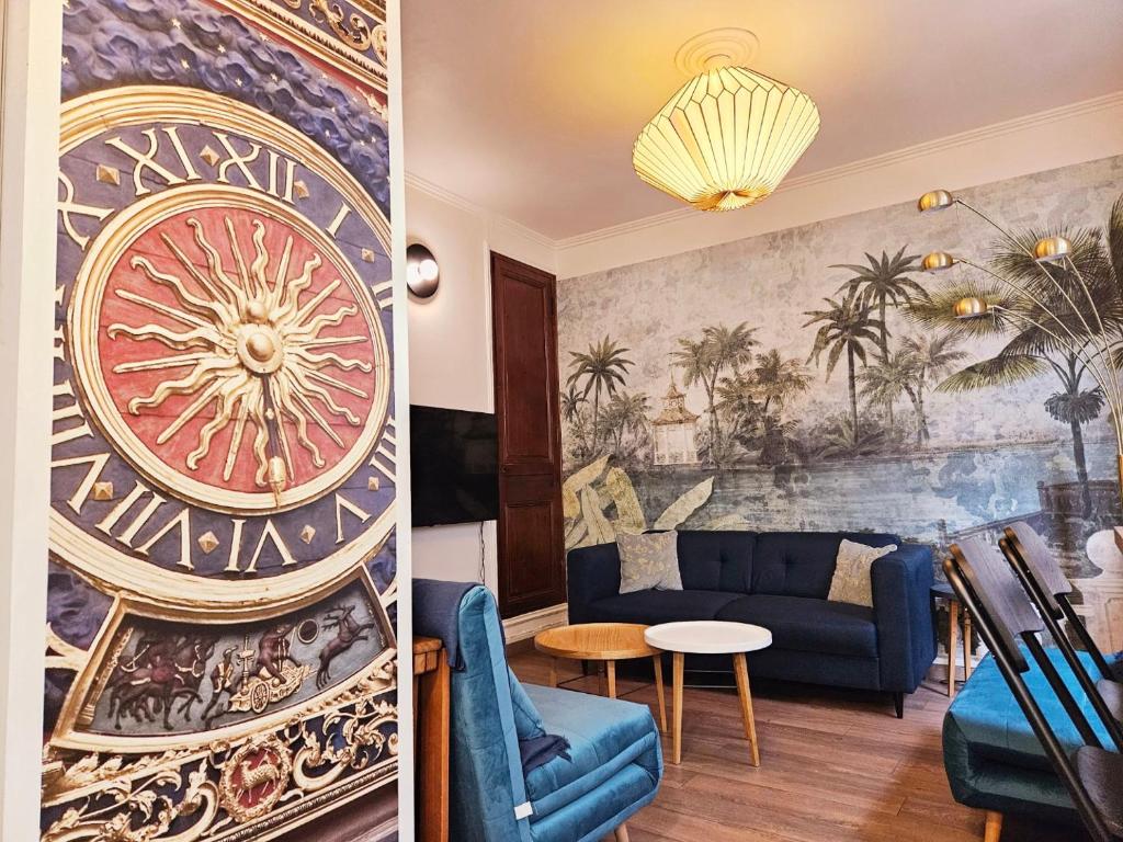 - un salon avec un canapé bleu et une fresque murale dans l'établissement L'impasse du Mail, à Rouen