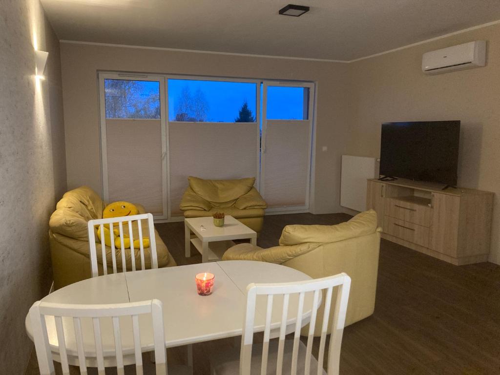 a living room with a white table and a tv at Smile Apartment in Osielsko