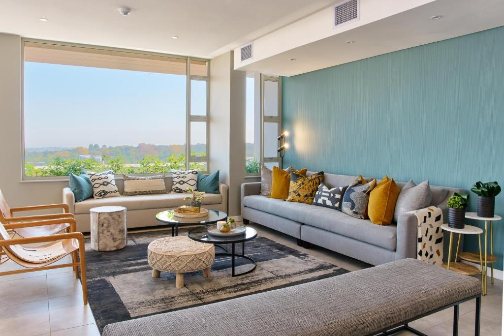 a living room with a couch and a table at The Serviced Apartment Collection At The Tyrwhitt Rosebank in Johannesburg