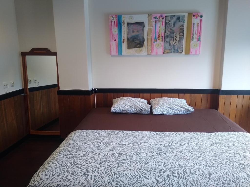 a bedroom with a bed with two pillows on it at Melaya Private Rooms in Faro