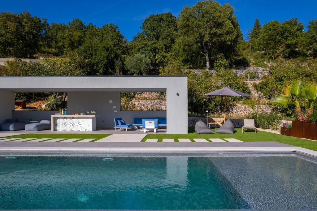 a swimming pool in a backyard with a house at Luxury Villa Depollo in Donji Vinjani