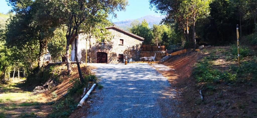 una carretera frente a una casa con un edificio en Masia Casa Nova de n'Illa, en Montseny