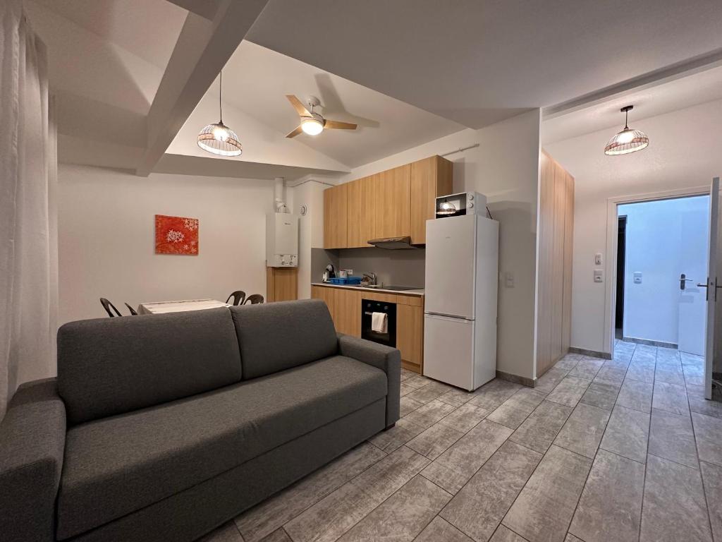 a living room with a couch and a kitchen at Résidence 4T IMMO - 31 Avenue Gaston Chauvin in Aulnay-sous-Bois