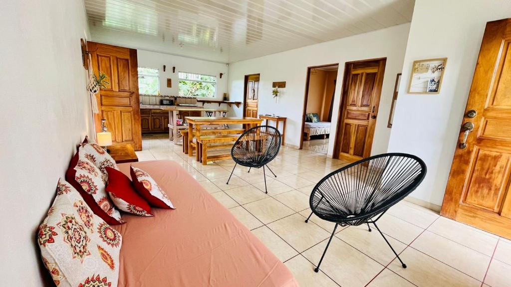 ein Wohnzimmer mit einer Couch und zwei Sesseln in der Unterkunft Cozy coworking Casa Alma near Lake Arenal, 2 bedroom 1 office, fiber optic, pet friendly in Nuevo Arenal