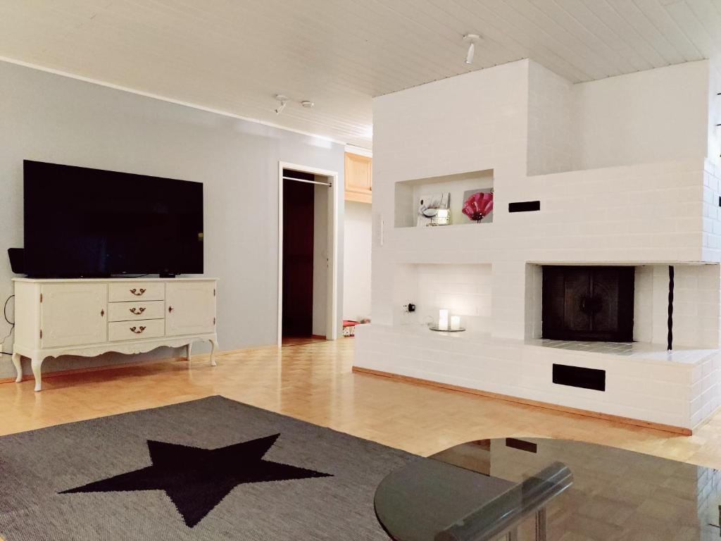 a living room with a television and a fireplace at Tilava asunto saunalla in Kuusamo