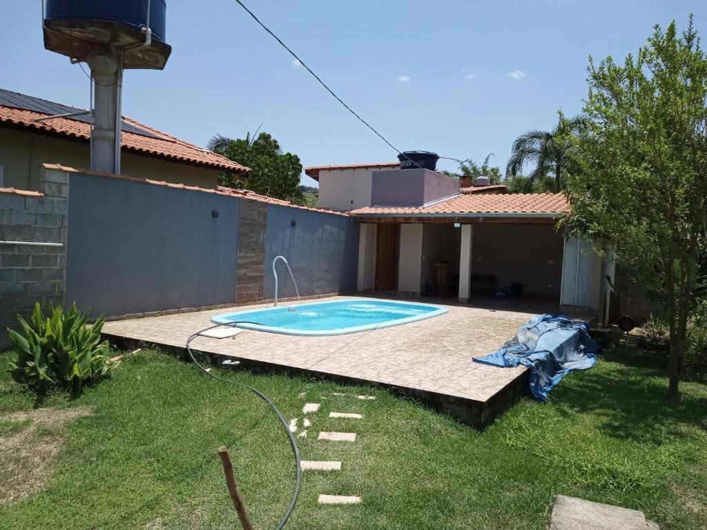un patio trasero con piscina y una casa en Chacara São Pedro, en Socorro