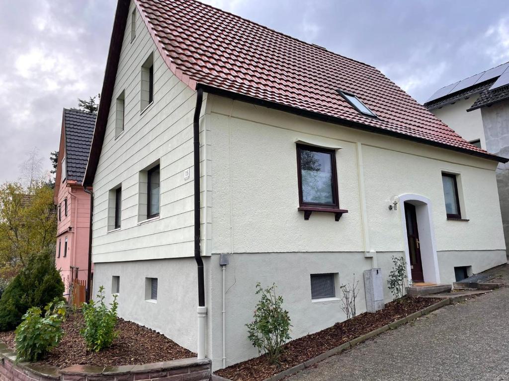 een wit huis met een rood dak bij Ferienhaus Lichtenberg in Herleshausen