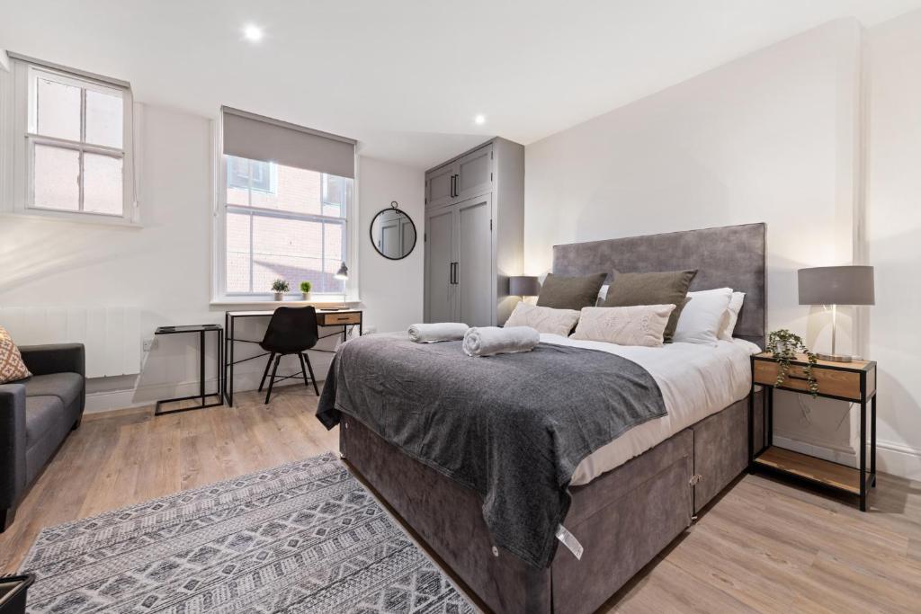 a bedroom with a large bed and a desk at The Market Street Studios in Nottingham