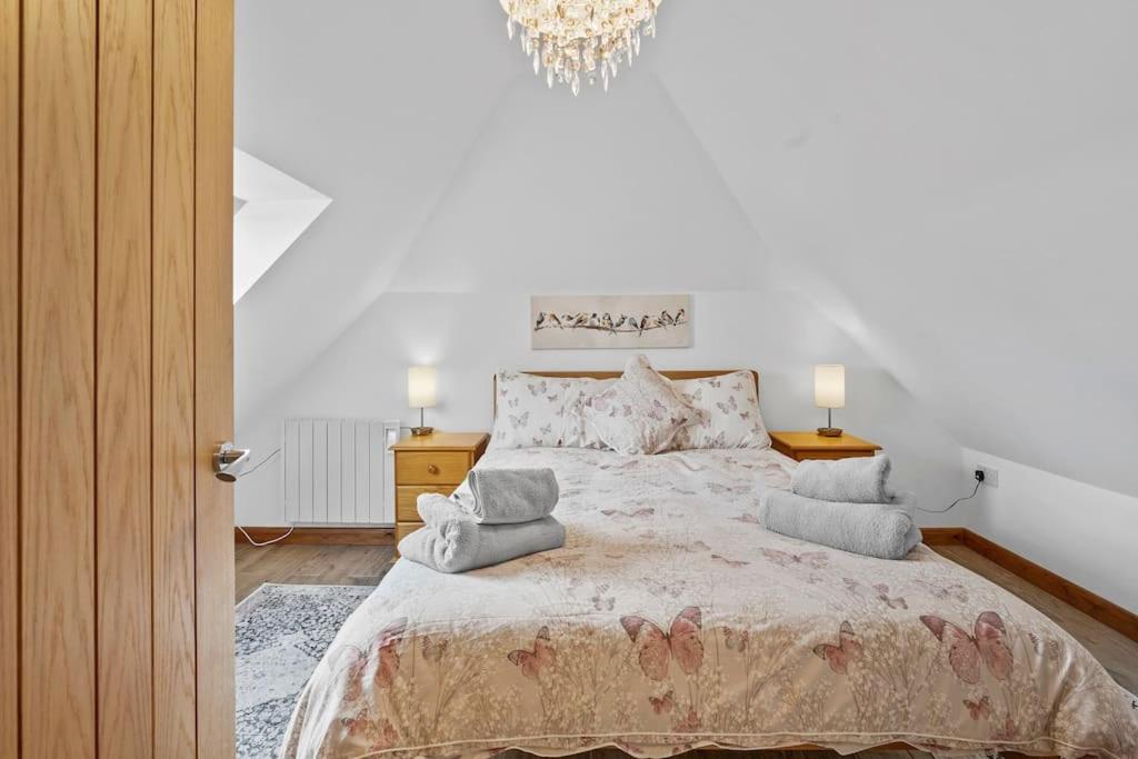 a bedroom with a large bed with a chandelier at Orchard View in Ash